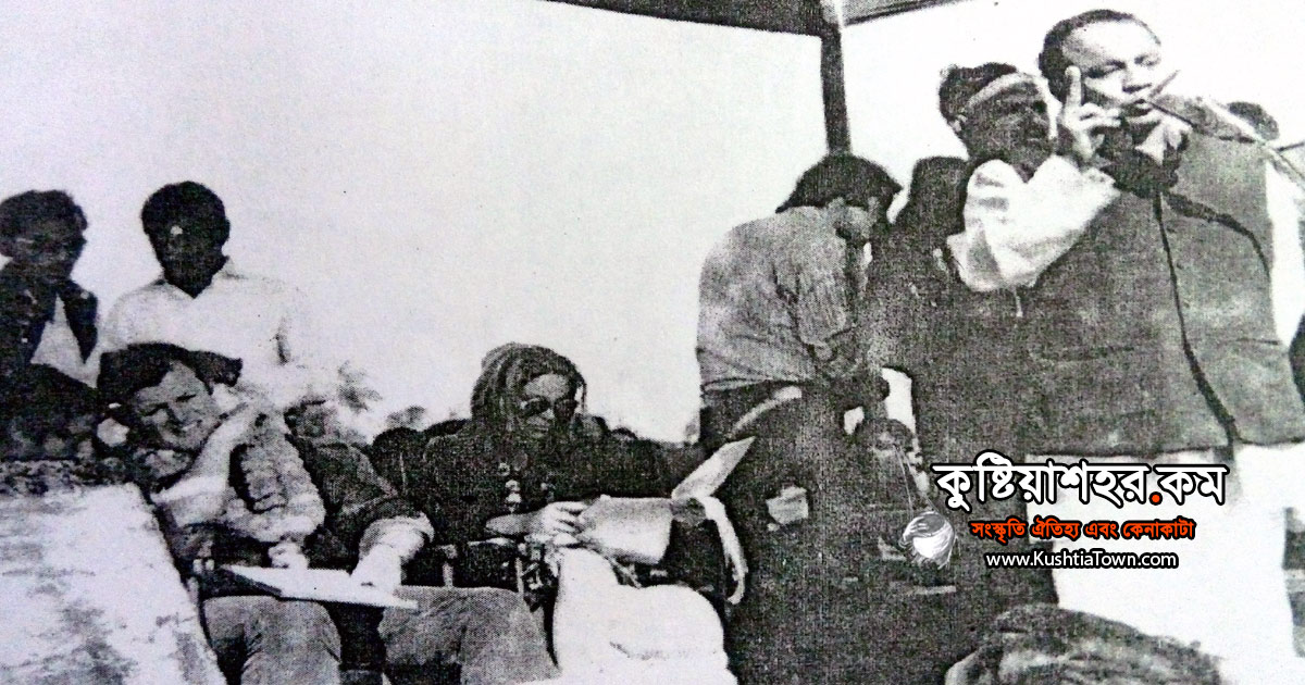 স্বাধীনতার পর কুষ্টিয়া পুলিশ লাইনে মঞ্চে উপবিষ্ট জন এ কেনেডী এবং পাশে বক্তৃতা দিচ্ছেন কামরুজ্জামান।